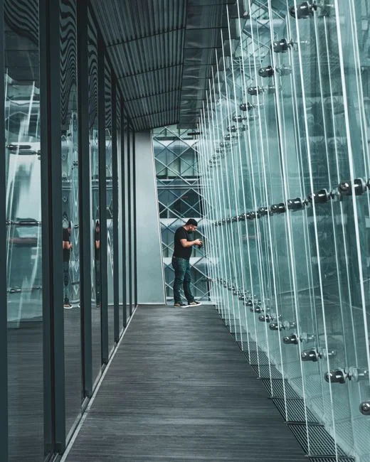 Vista dall’alto di una governante anonima con guanti di gomma gialli che spruzza detergente su un rubinetto cromato del bagno